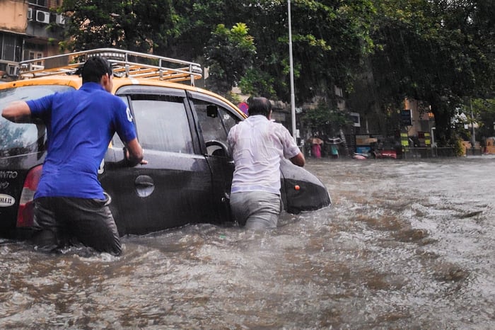 Men pushing car flood water