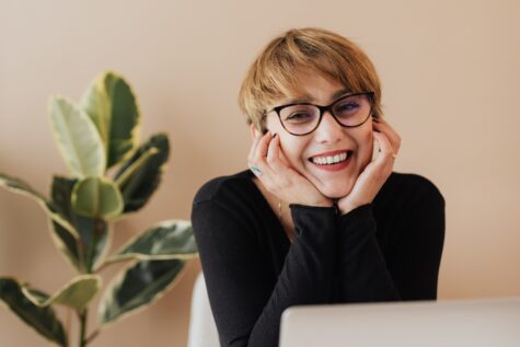 Smiling woman behind laptop with scalable grant software